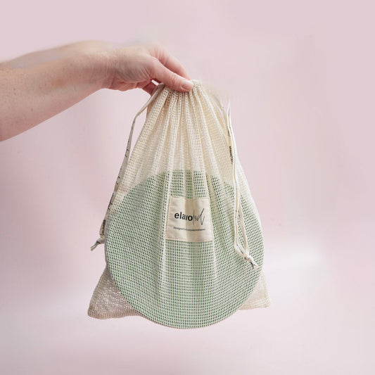 hand holding a mesh bag with plates