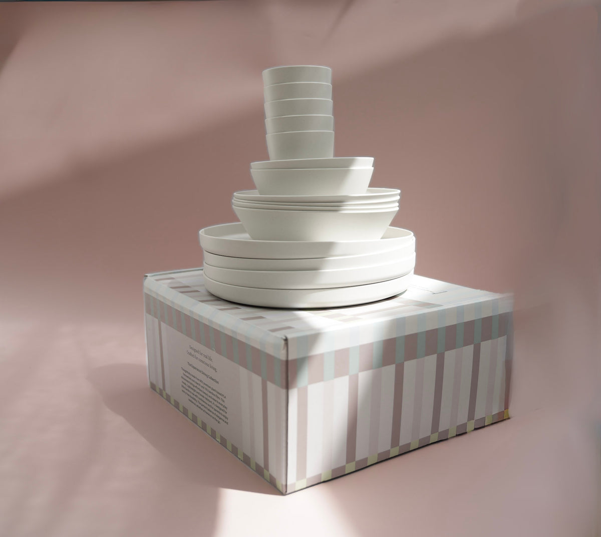 Large box with stacked white cups and plates