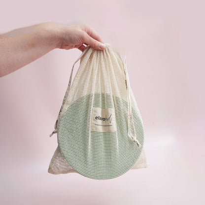 hand holding a mesh bag with plates