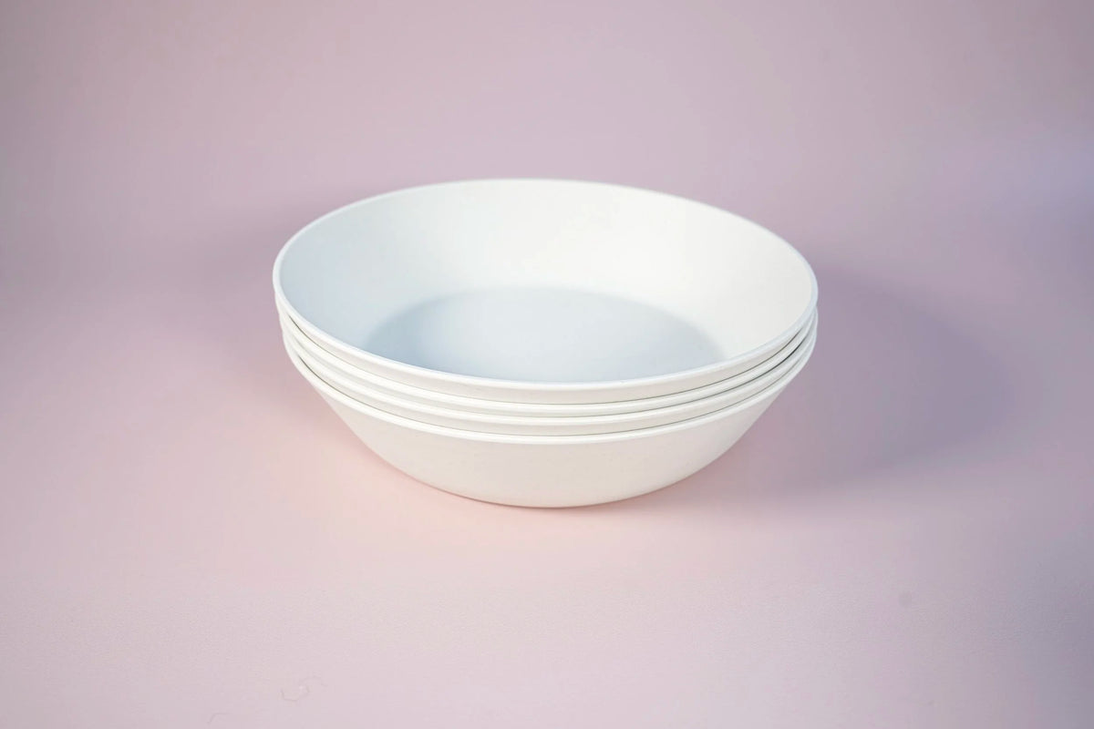 white bowls in a set of four on a pink background