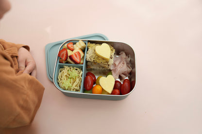 Lunch box fulled with food like cheese ham and strawberries. 