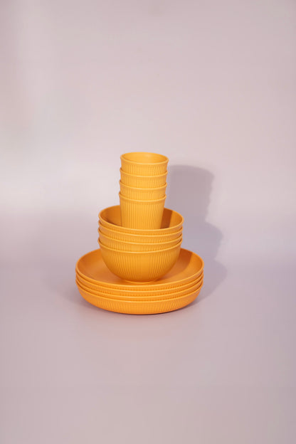 Yellow set of yellow wheat straw plates bowls and cups.
